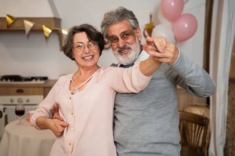 Pareja mayor celebrando entre globos